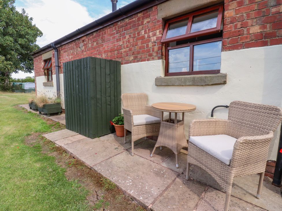 An outdoor seating area with chairs and table at The Stables Hall Green near Walmer Bridge