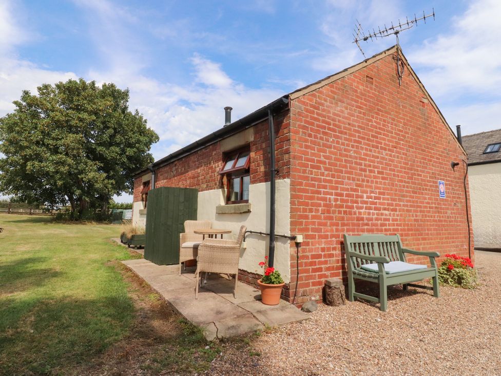 An outdoor area with a bench and plants at The Stables in Hall Green near Walmer Bridge