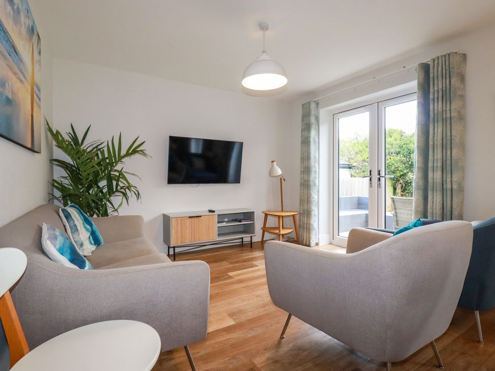 A living room with a television and seating area at Chi Gwynn in Crantock