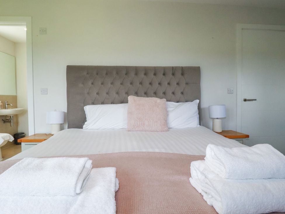 A bedroom with a bed and lamps at Chi Gwynn in Crantock