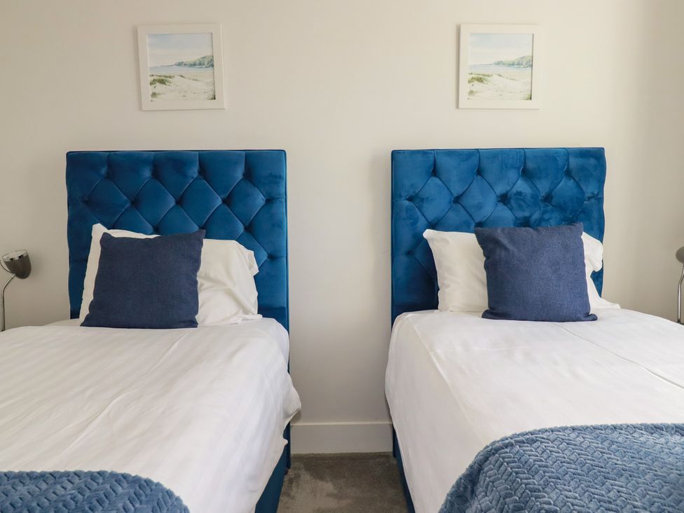 A bedroom with twin beds and a decorative picture at Chi Gwynn in Crantock