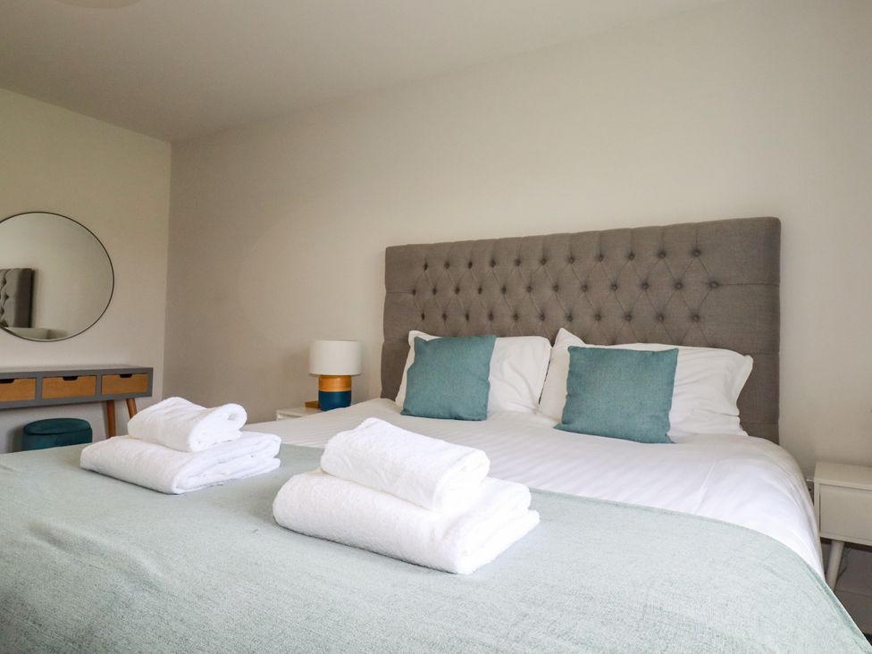 A bedroom with a bed and towels at Chi Gwynn in Crantock