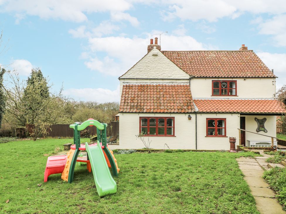 A house with a slide in the garden at Woodpit Cottage in Watnall