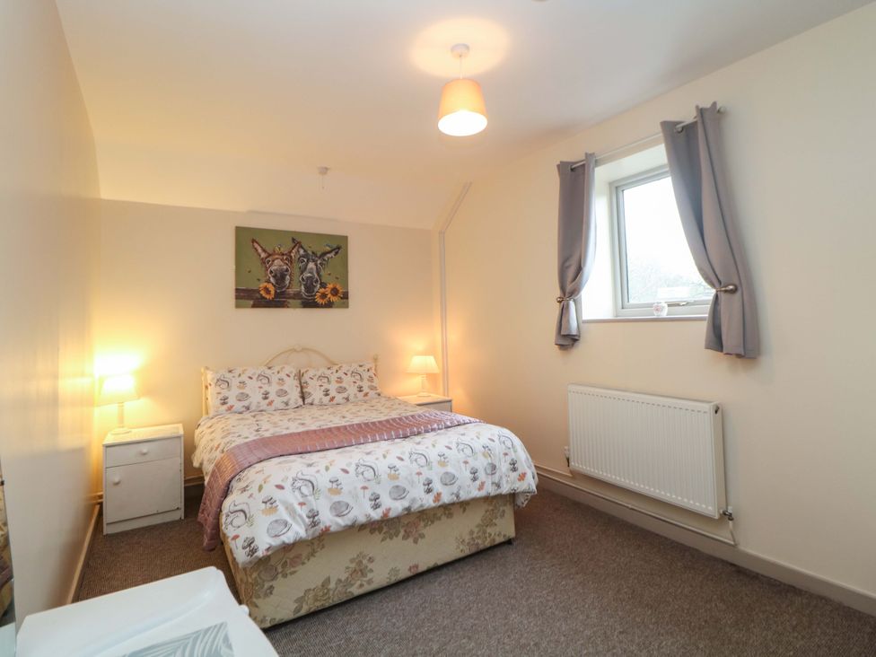 A bedroom with a bed and nightstand at Ford Coach House Cottage in Ford near Leek