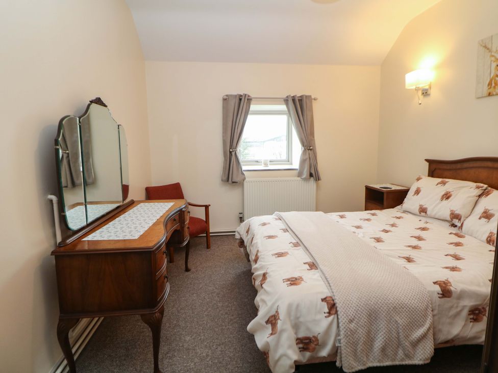 A bedroom with a bed and a dressing table at Ford Coach House Cottage Ford near Leek