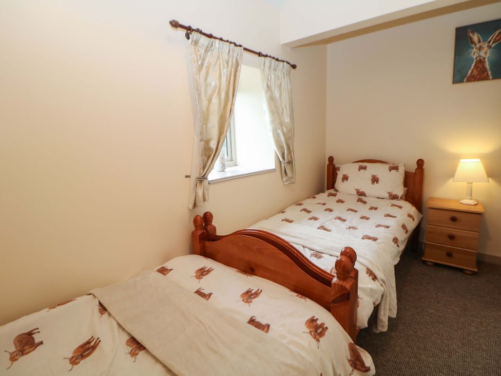 A bedroom with two beds and a window at Ford Coach House Cottage Ford near Leek