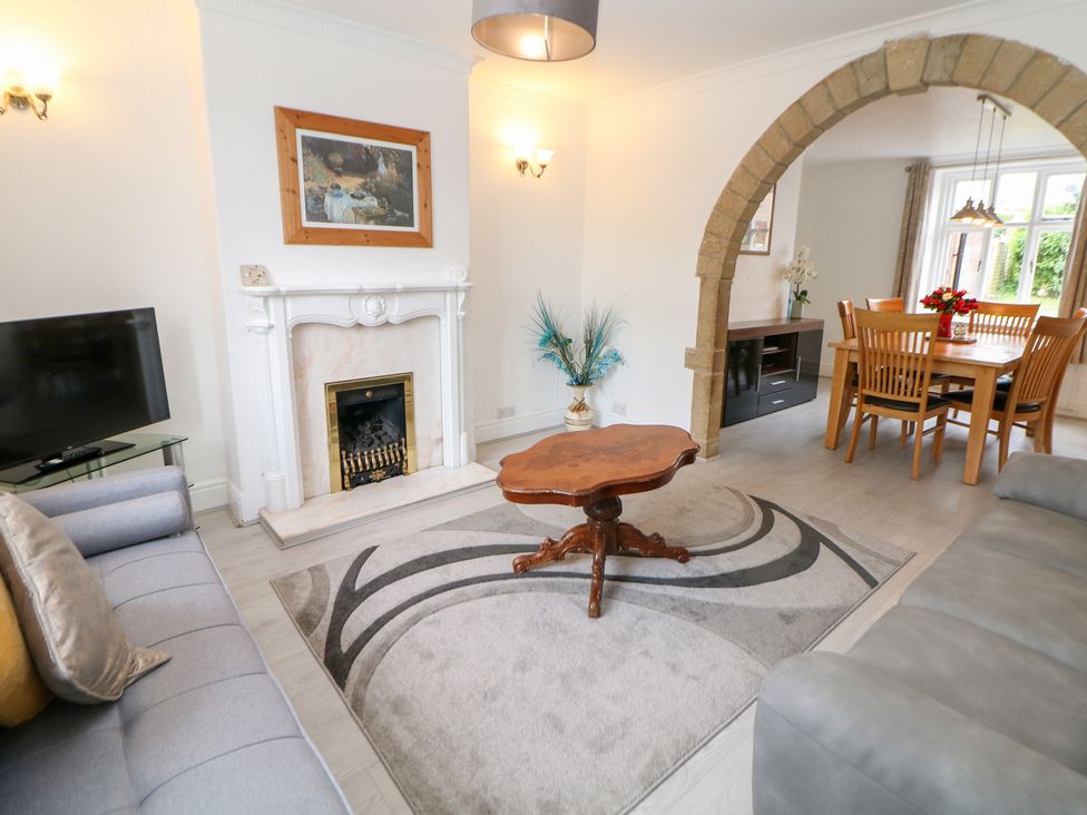 A living room with a sofa and fireplace at 15 Calton View in Bakewell
