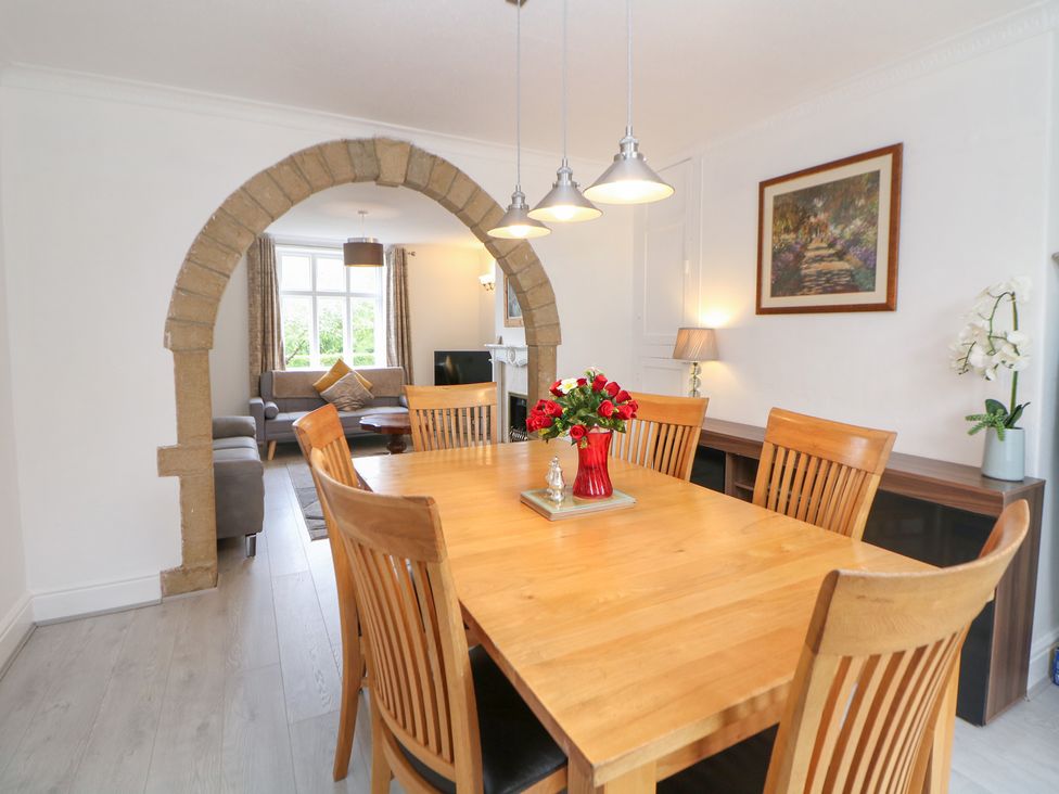 A dining room with a wooden table and chairs at 15 Calton View Bakewell