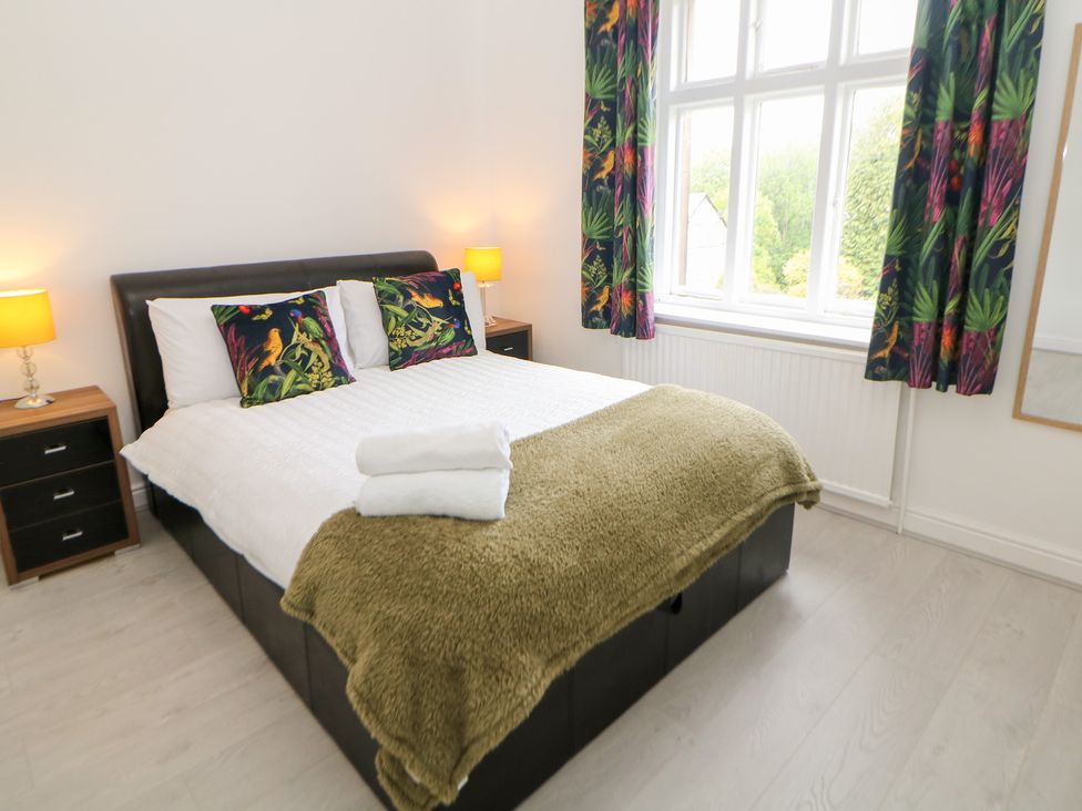 A bedroom with a bed and bedside lamps at 15 Calton View in Bakewell