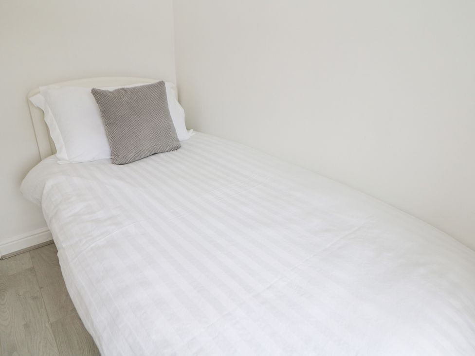 A bed with a pillow and a cushion at 15 Calton View, Bakewell