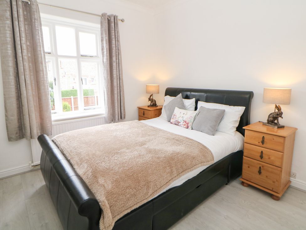 A bedroom with a bed and nightstands at 15 Calton View Bakewell