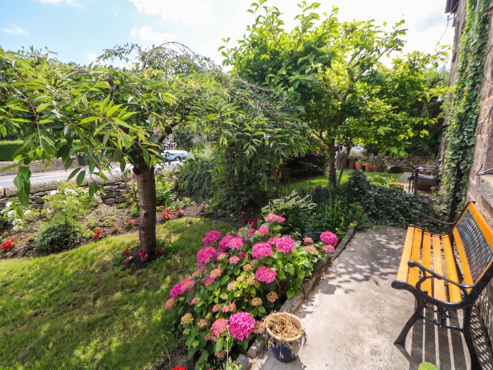 A garden with trees and flowers at Cherry Tree Cottage in Bakewell