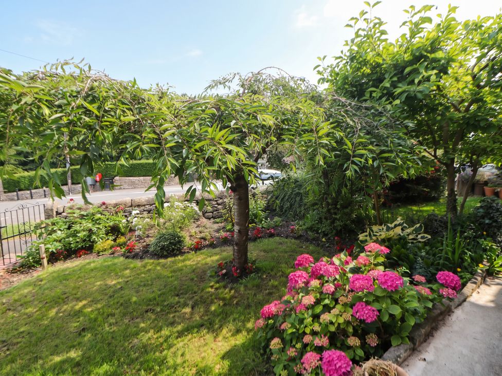 A garden with flowers and a tree at Cherry Tree Cottage Bakewell