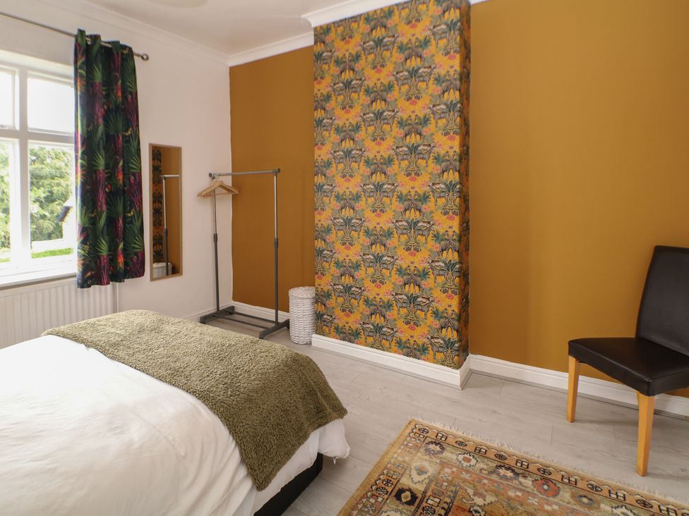 A bedroom with a bed and a rug at Cherry Tree Cottage in Bakewell