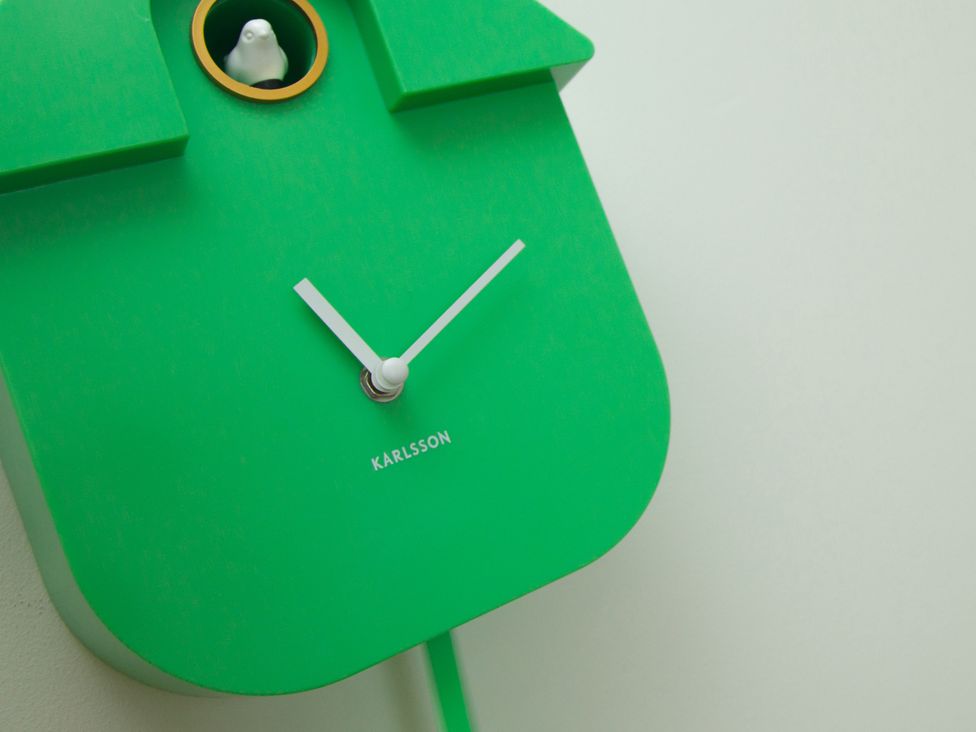 A green wall clock with a bird at Ultramarine in Carbis Bay