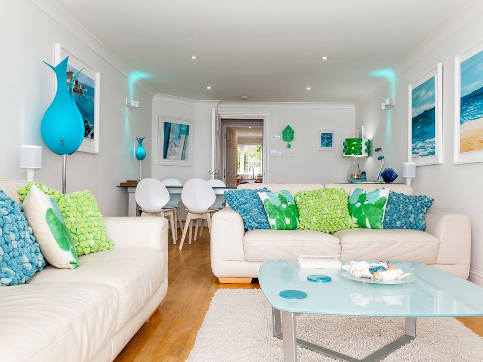 A living room with a sofa and table at Ultramarine in Carbis Bay