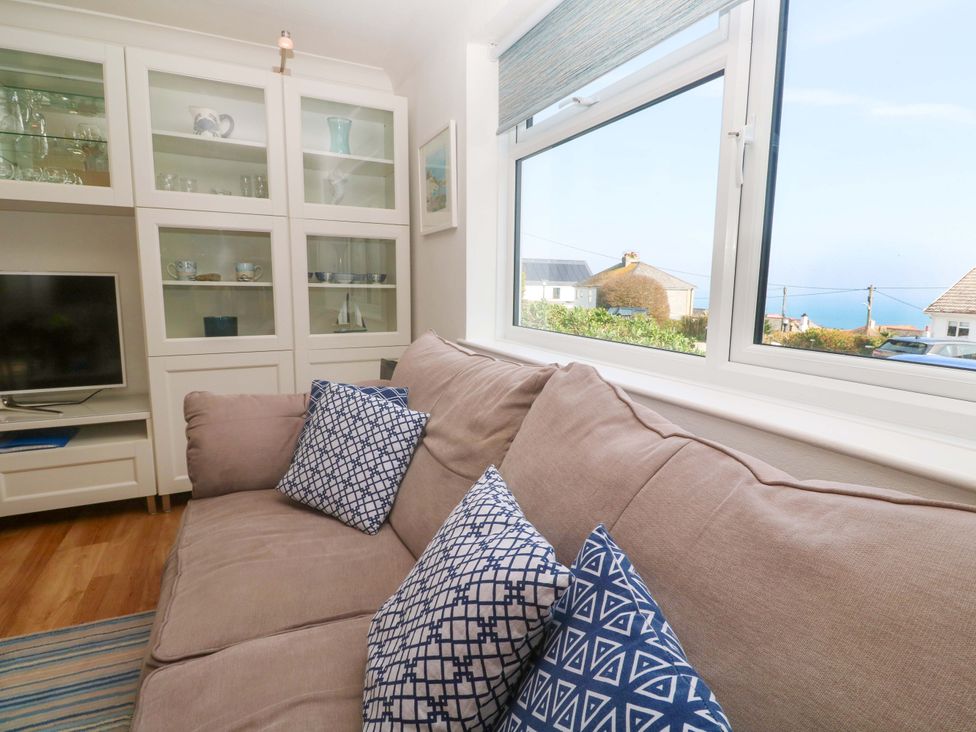 A living room with a sofa and television at Atlantic Waves in Carbis Bay