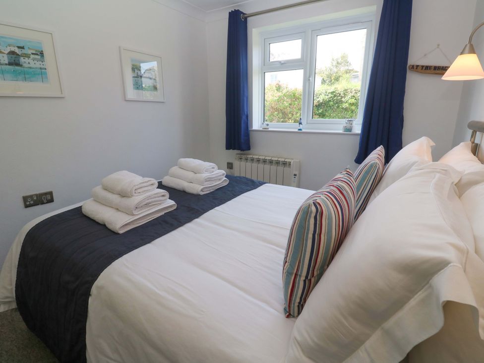 A bedroom with a bed and towels at Atlantic Waves in Carbis Bay