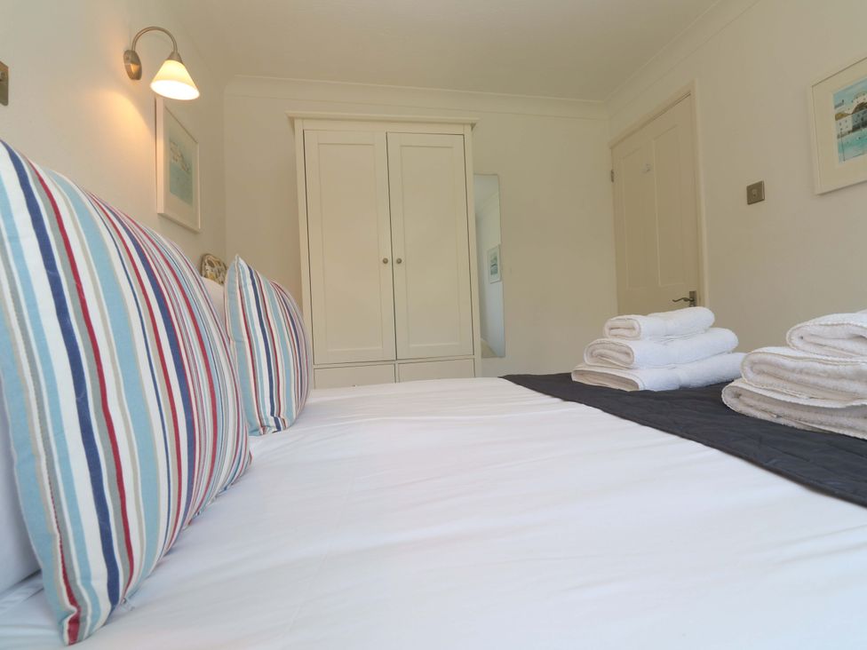 A bedroom with a bed and towels at Atlantic Waves in Carbis Bay