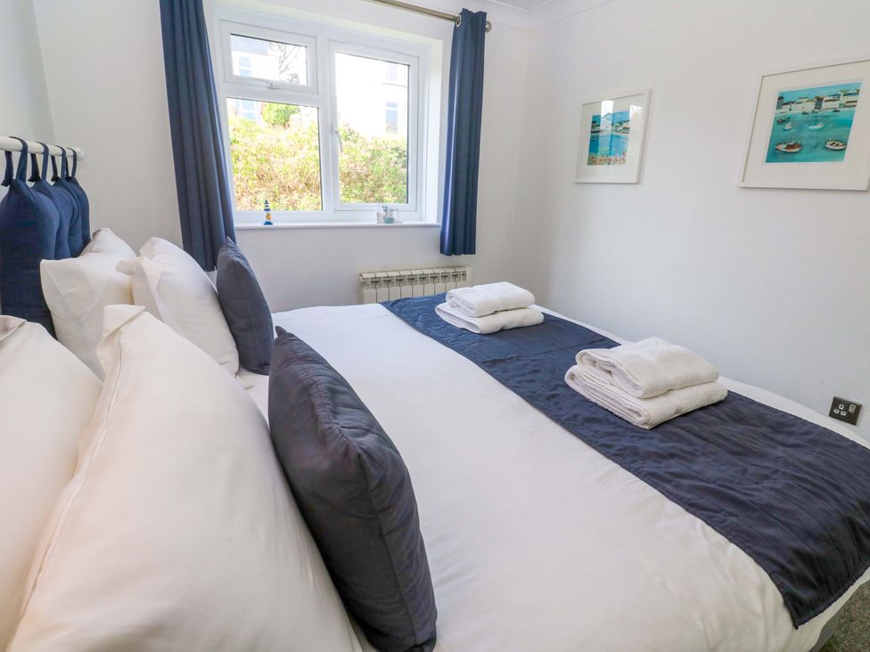 A bedroom with a bed and towels arranged on it at Atlantic Waves in Carbis Bay
