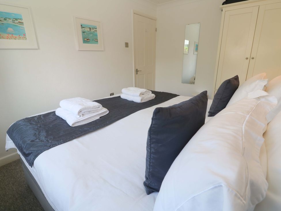 A bedroom with a bed and towels at Atlantic Waves in Carbis Bay