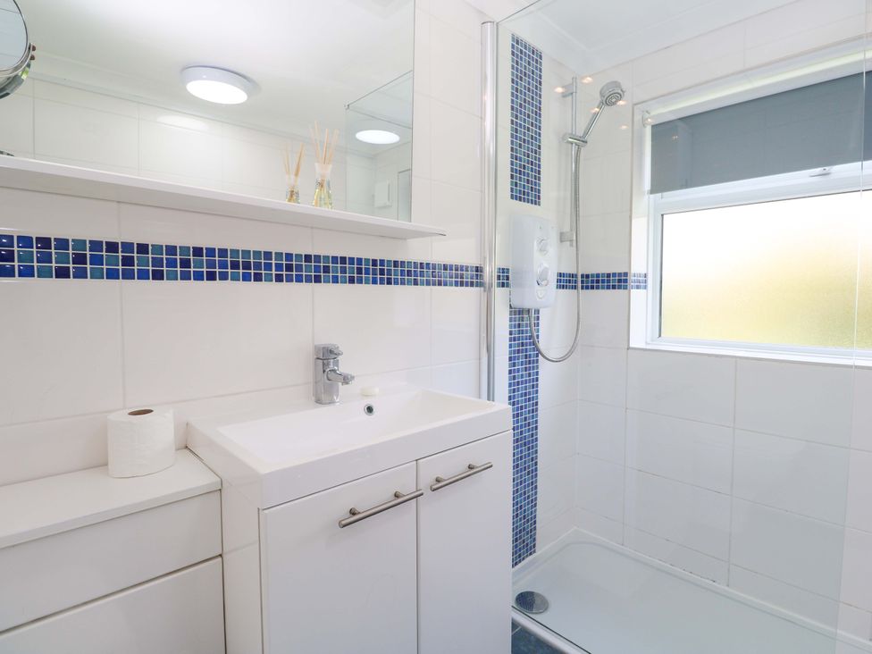 A bathroom with a sink, shower, and cabinet at Atlantic Waves in Carbis Bay