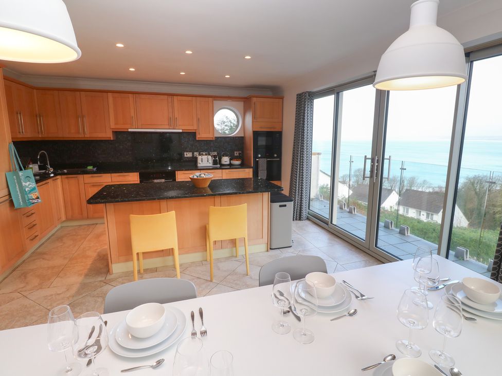 A kitchen with wooden cabinets and a dining table at Bayside in Carbis Bay