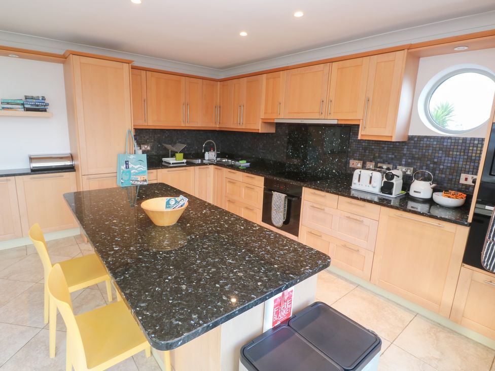A kitchen with a granite countertop and cabinets at Bayside in Carbis Bay