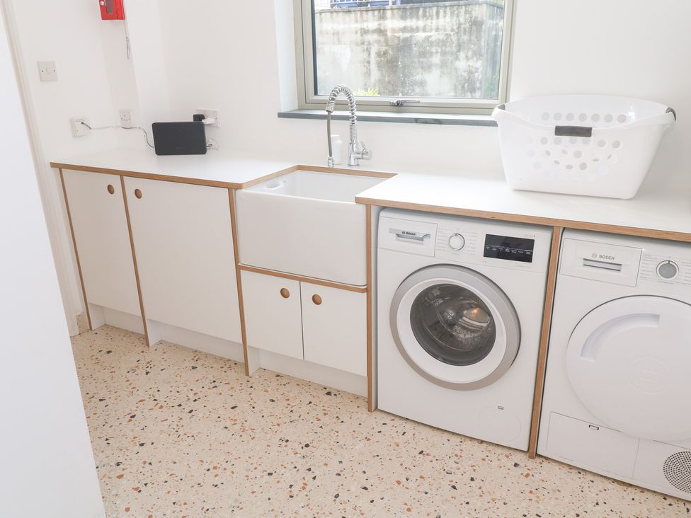 A laundry room with a washing machine and sink at Bayside in Carbis Bay