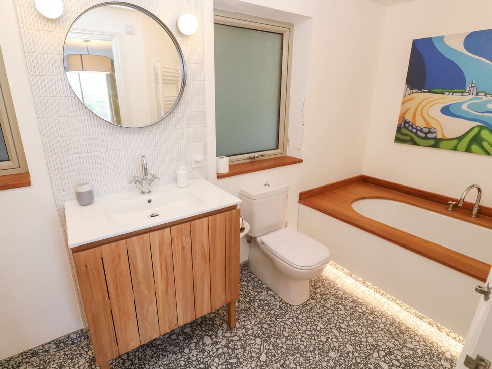 A bathroom with a vanity sink, toilet, and bathtub at Bayside in Carbis Bay