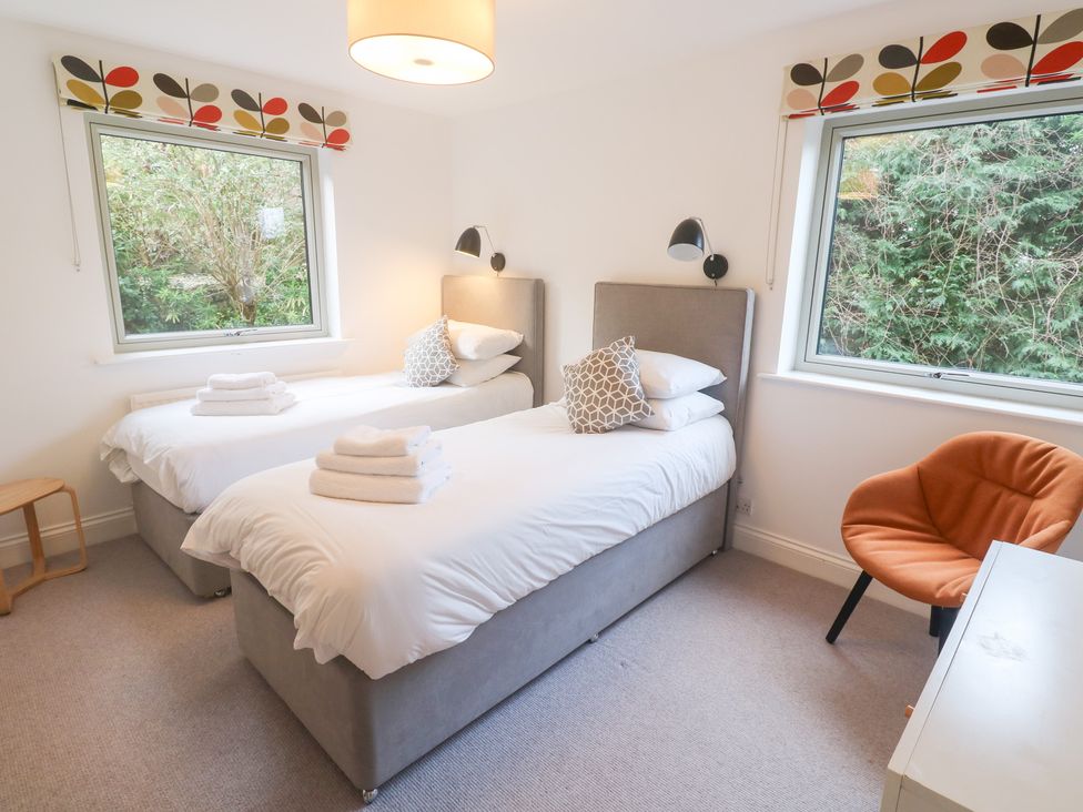 A bedroom with two beds and a chair at Bayside in Carbis Bay