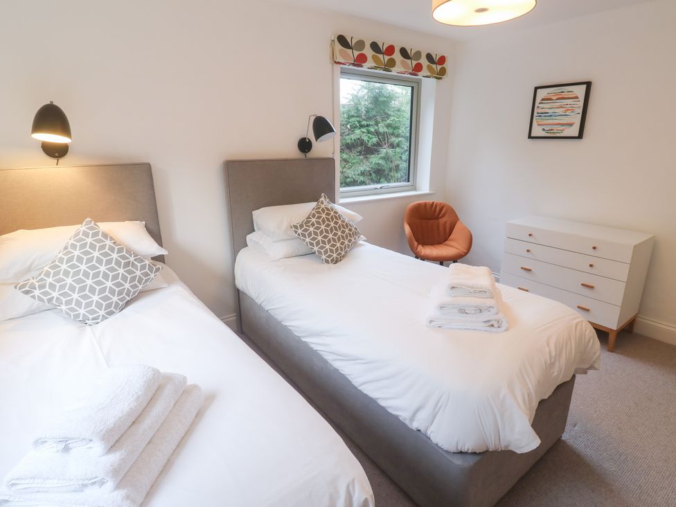 A bedroom with twin beds and a dresser at Bayside in Carbis Bay