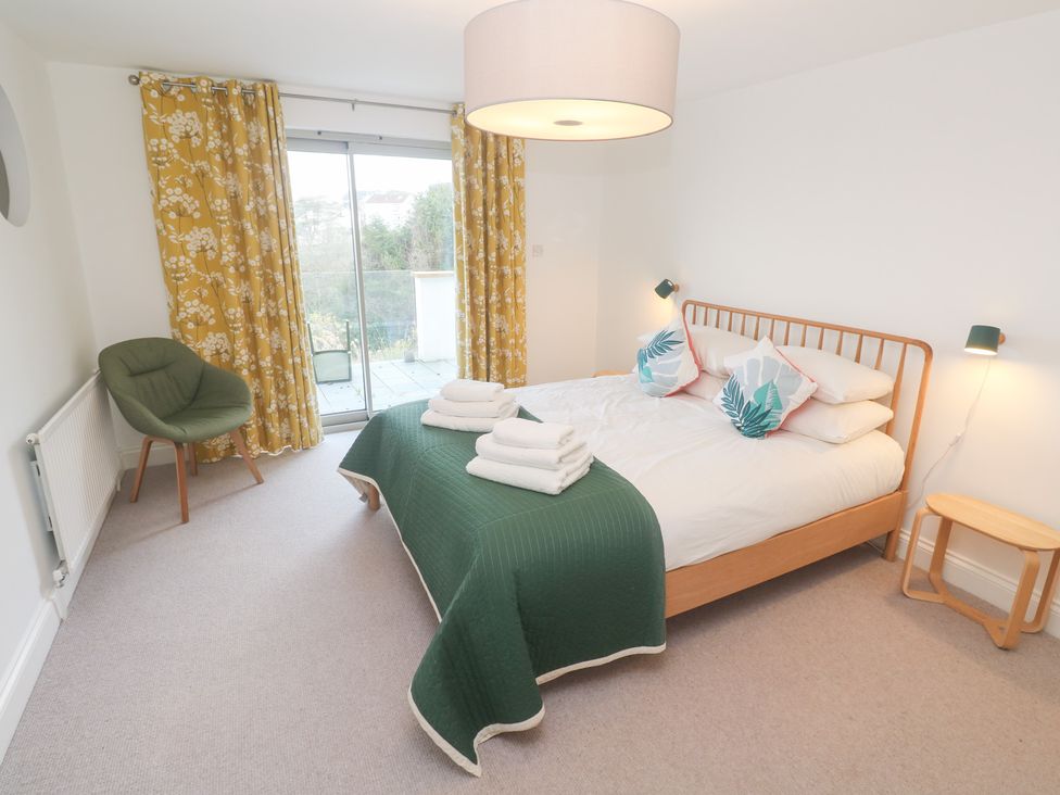A bedroom with a bed and chair at Bayside in Carbis Bay
