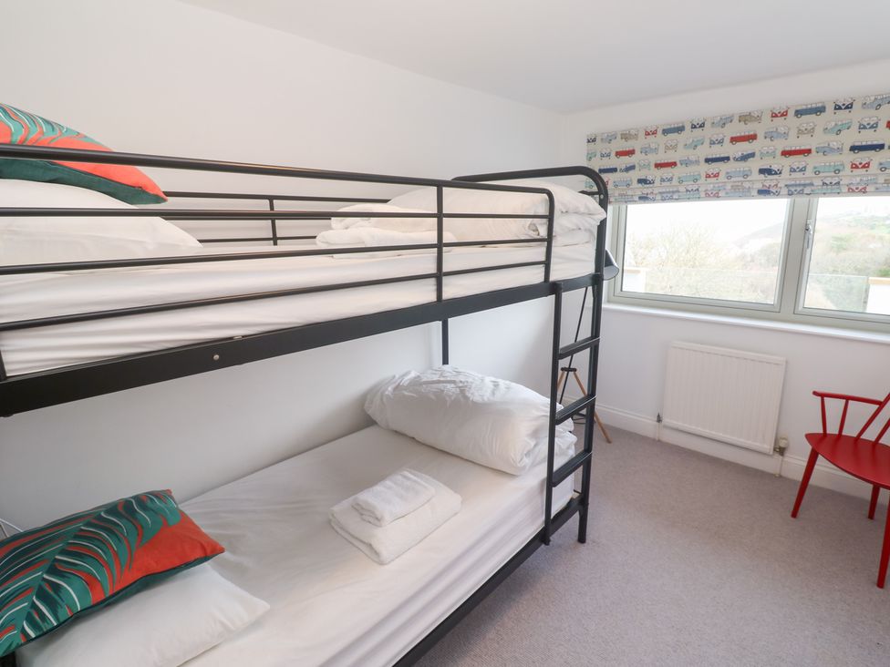 A bedroom with a bunk bed and a red chair at Bayside in Carbis Bay