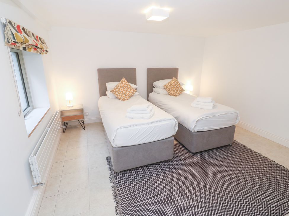 A bedroom with two beds and a nightstand at Bayside in Carbis Bay