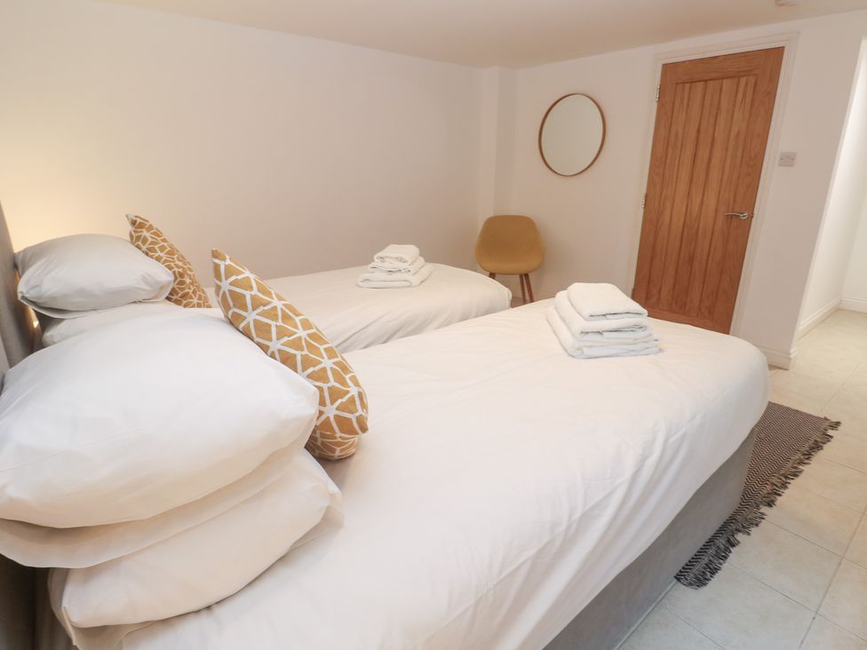A bedroom with two beds and a door at Bayside in Carbis Bay