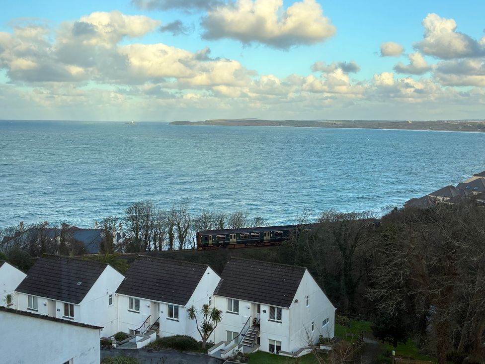 An ocean view with a train passing through houses at Bayside in Carbis Bay