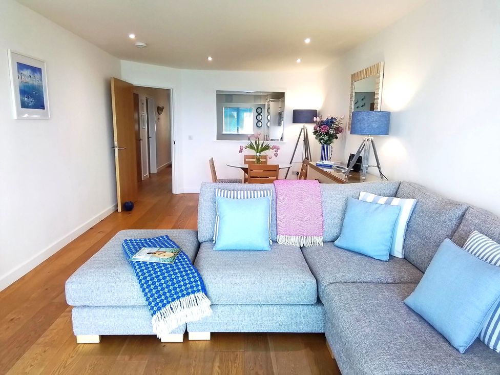 A living room with a sofa and a table at Sea Mist in Carbis Bay