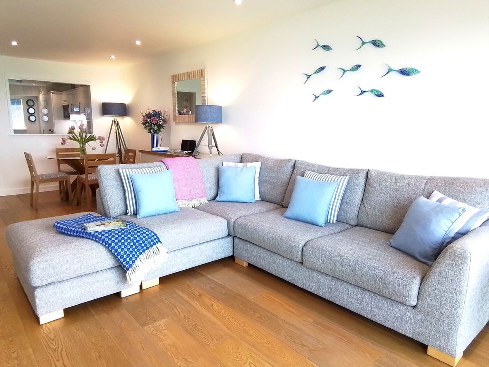 A living room with a sofa and dining area at Sea Mist in Carbis Bay