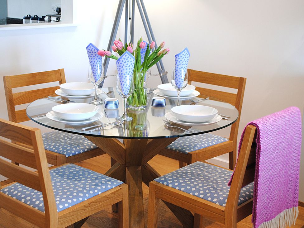 A dining room with a round table set for a meal at Sea Mist in Carbis Bay