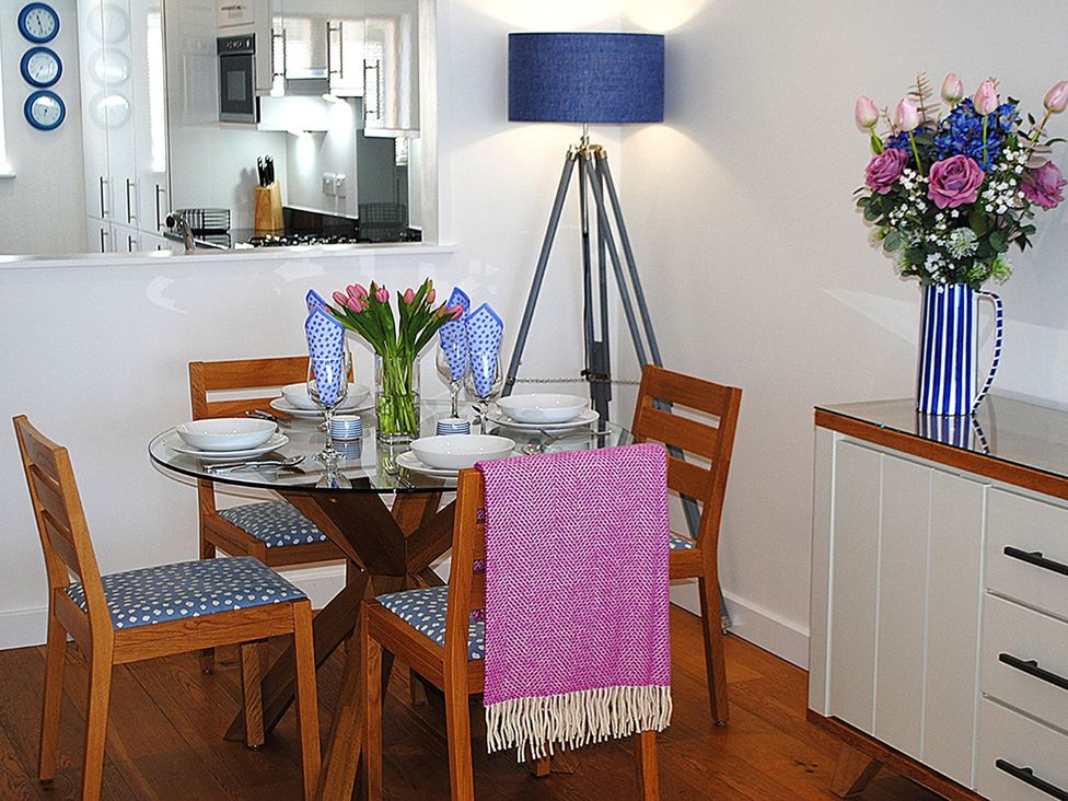 A dining room with a round table set for four at Sea Mist in Carbis Bay