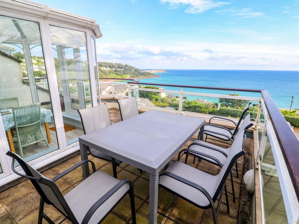 An outdoor terrace with a table and chairs at Ocean Gem in Carbis Bay