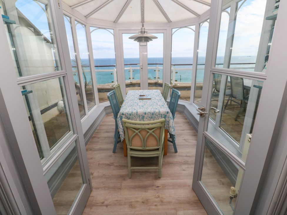 A conservatory with a table and chairs at Ocean Gem in Carbis Bay