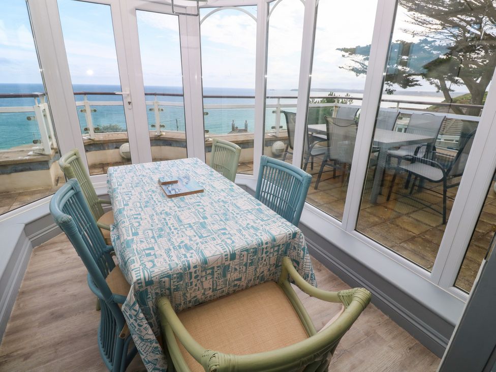 A conservatory with a dining table and chairs at Ocean Gem in Carbis Bay