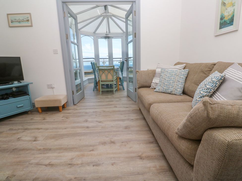 A living room with a sofa and television at Ocean Gem in Carbis Bay