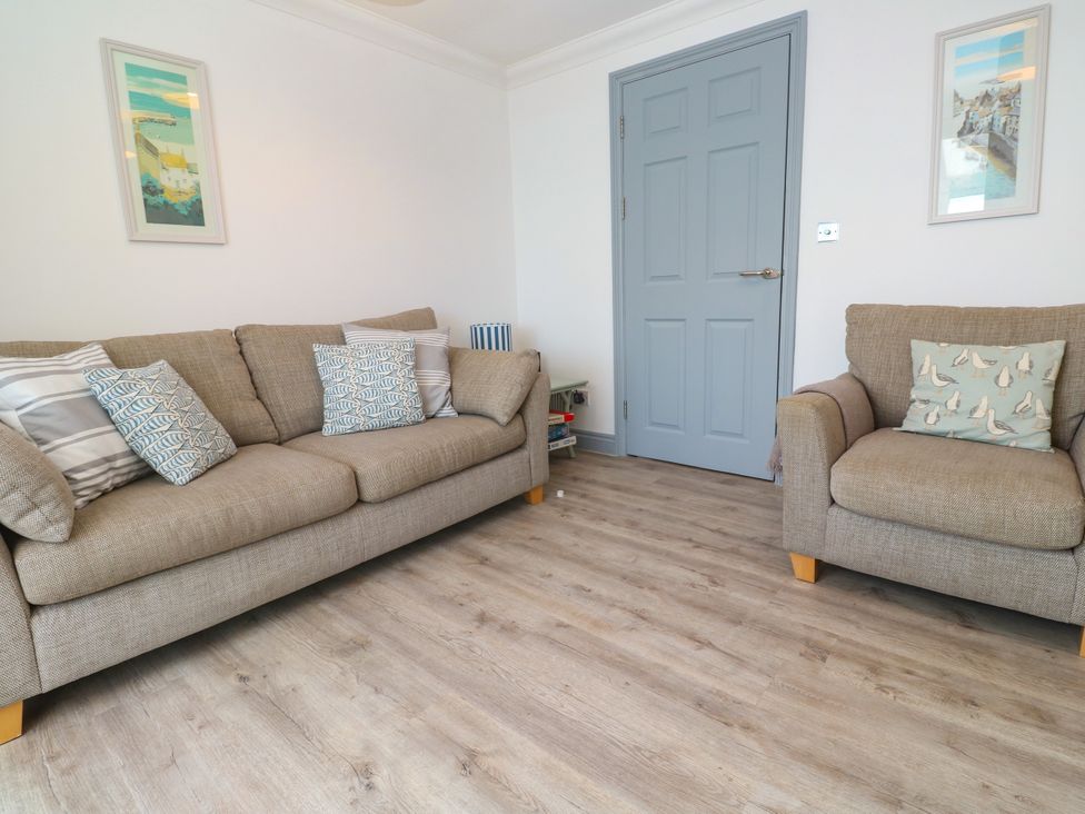 A living room with a sofa and armchair at Ocean Gem in Carbis Bay
