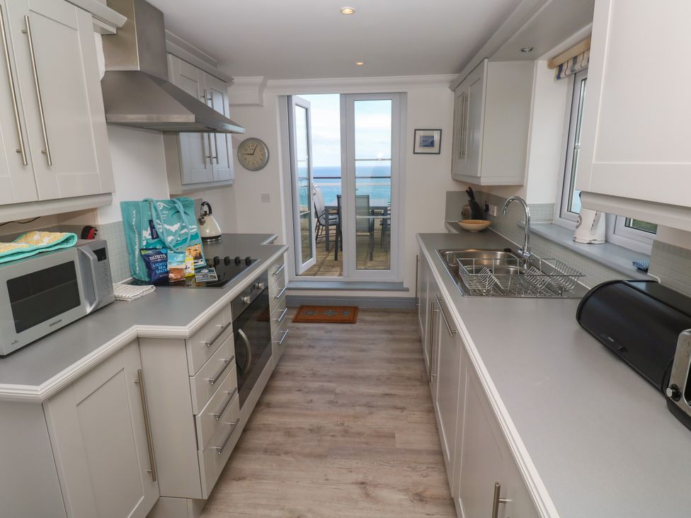 A kitchen with appliances and a view at Ocean Gem in Carbis Bay