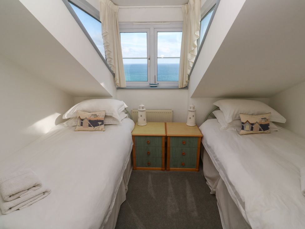 A bedroom with two beds and a view of the sea at Ocean Gem in Carbis Bay
