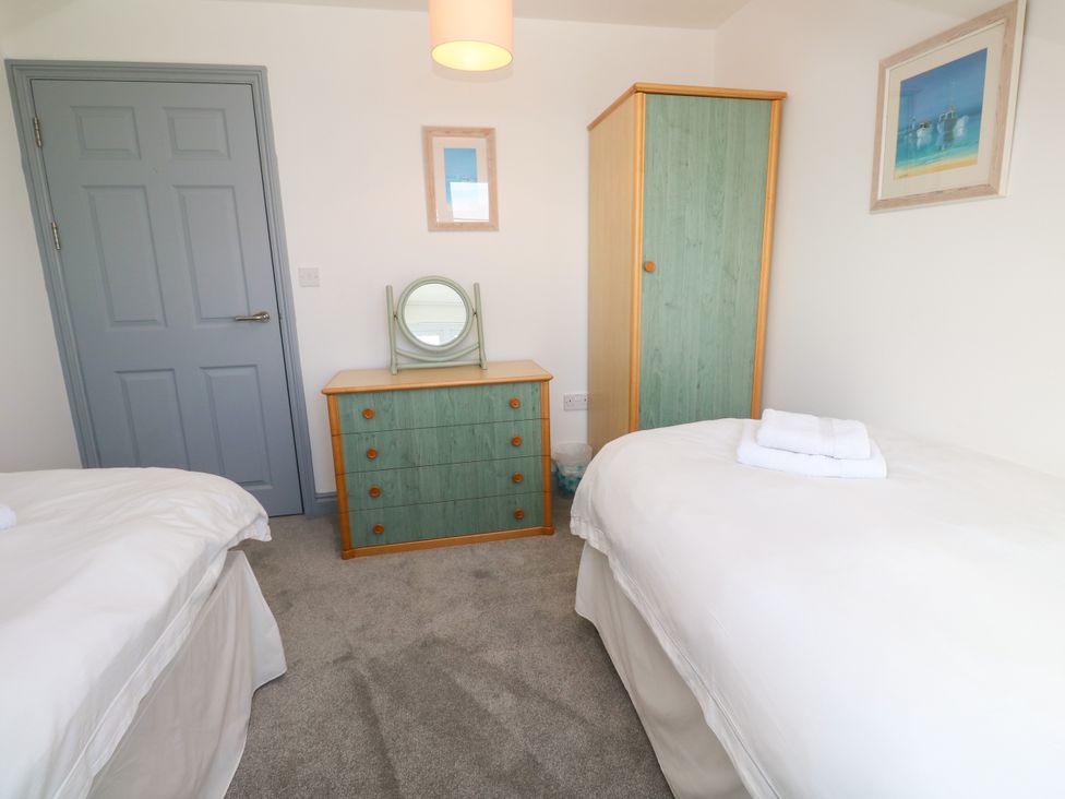 A bedroom with a dresser and wardrobe at Ocean Gem in Carbis Bay