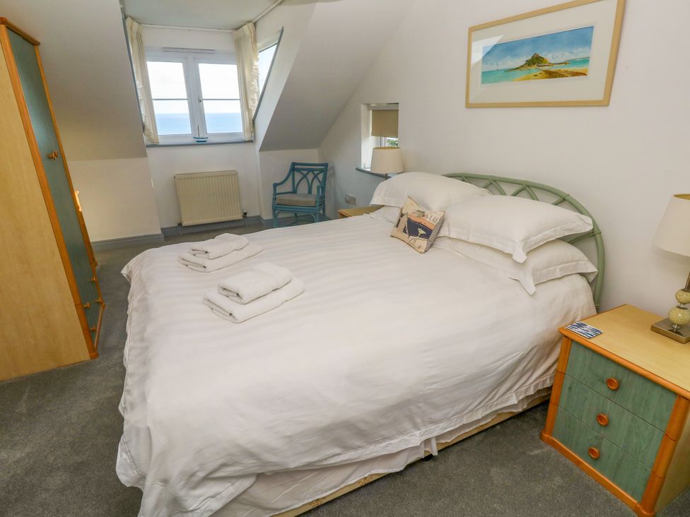 A bedroom with a bed and chair at Ocean Gem in Carbis Bay